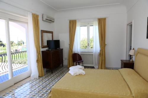 Habitación de hotel con cama y balcón en La Cicas, en Anacapri