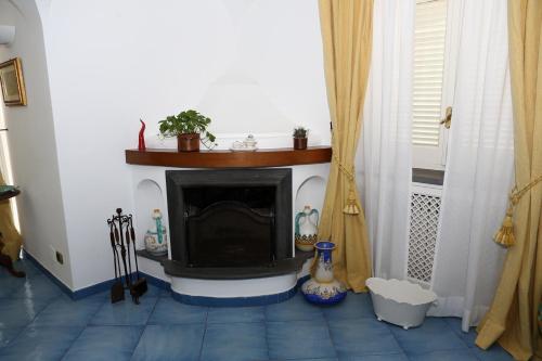 a fireplace in a living room with a blue tile floor at B&B Villa La Cicas in Anacapri