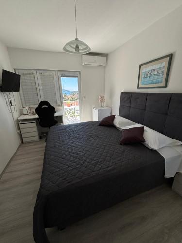 a bedroom with a large bed and a desk at Bjelopera Rooms in Zaton