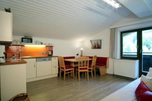 a kitchen and dining room with a table and chairs at Pension Forsthof in Maishofen