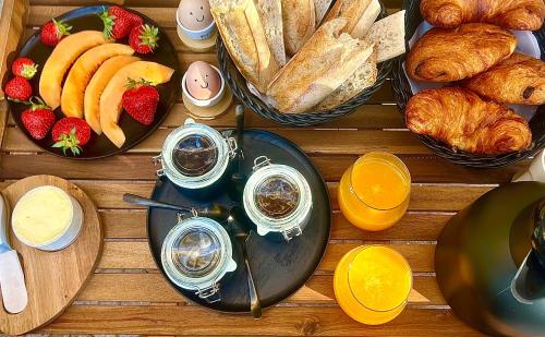 een houten tafel met brood en gebak bij Chambre L in Les Taillades
