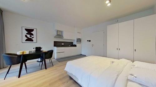 a bedroom with a bed and a desk and a bed and a table at Demeure Metropolitain in Liège