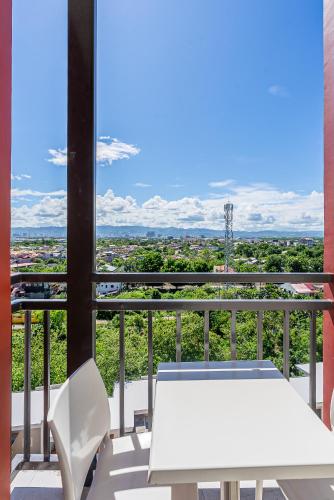 une table blanche et des chaises sur un balcon avec vue dans l'établissement Comfy City Studio with Balcony and Sunsets, à Lapu Lapu City