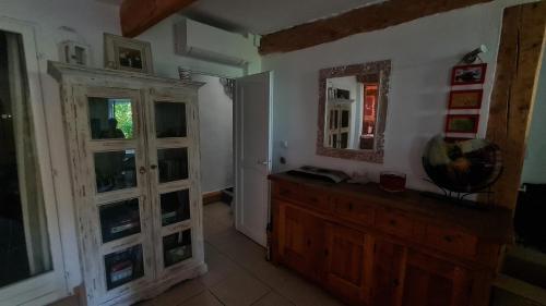 Cette chambre comprend un miroir et une commode en bois. dans l'établissement Vacances reposantes, à La Celle-sous-Gouzon