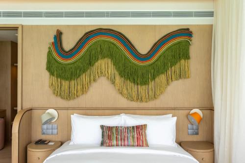 a bedroom with a bed with a painting on the wall at SO/ Maldives in South Male Atoll