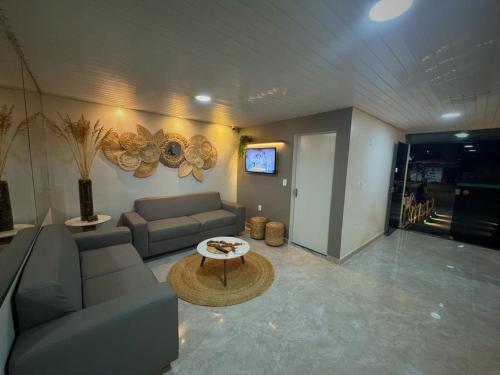 una sala de estar con un sofá y una mesa en Veleiro Hotel MCZ, en Maceió
