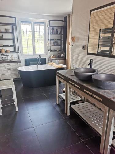 La grande salle de bains est pourvue de 2 lavabos et d'une baignoire. dans l'établissement Oasis de Détente avec Piscine et Jacuzzi 300m2, à Roézé-sur-Sarthe