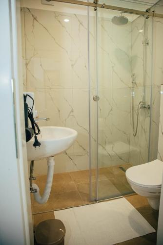 a bathroom with a sink and a glass shower at Wellness Spa Hotel Zeleni Raj in Banja Luka
