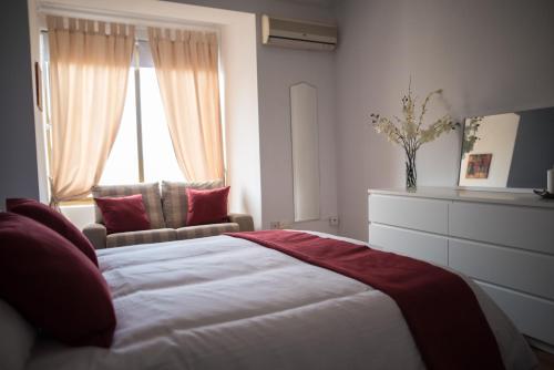 a bedroom with a bed and a chair and a window at San Salvatore in St Julian's