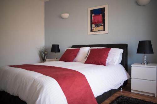 a bedroom with a large bed with red and white pillows at San Salvatore in St Julian's