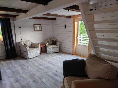 a living room with two chairs and a couch at Mysigt boende på landet in Vimmerby