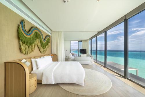 a bedroom with a bed and a view of the ocean at SO/ Maldives in South Male Atoll