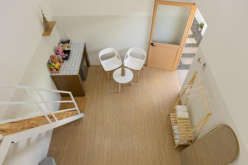 a small room with two white chairs and a table at Kim Quý Home in Phu Quoc