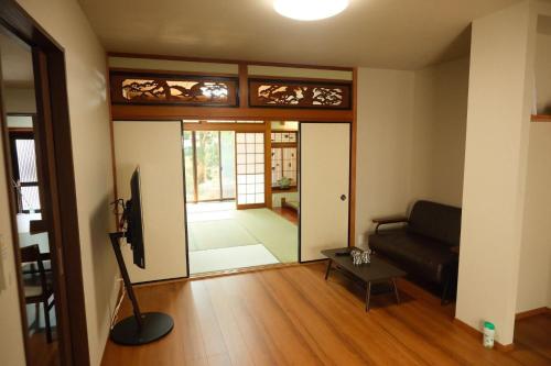a living room with a couch and a glass door at 墨松居 in Osaka