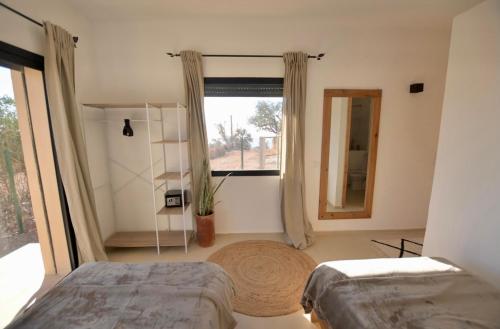 a bedroom with two beds and a large window at Argan House Morocco in Taghazout