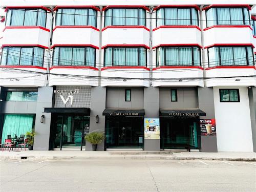 a white building with a red and white facade at V1 boutique hotel in Kanchanaburi