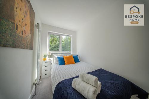 a bedroom with a bed with blue and orange pillows at Modern 4 Bed 3 Bath House - 4 Groups with FREE Parking - Central London in London
