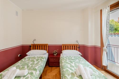 two beds in a room with a window at Il Nido sul Po in Casalmaggiore