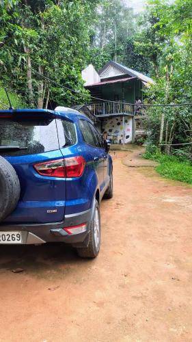 a blue car parked in front of a house at Green porticos villa munnar #MUNNAR in Anachal