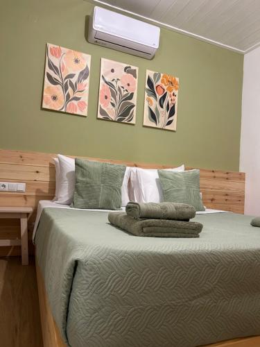 a bedroom with a bed with three pictures on the wall at Abigails Pool House in Kallirakhi