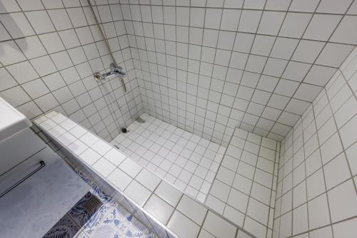 a bathroom with a shower with white tiles at Meng Yun Ge Hotel in Jiaoxi