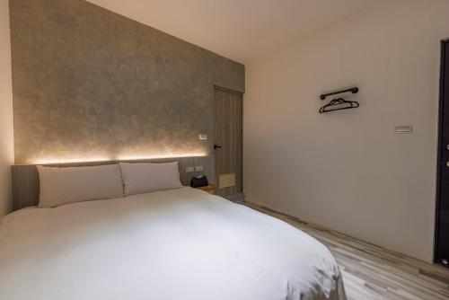 a bedroom with a white bed in a room at Meng Yun Ge Hotel in Jiaoxi