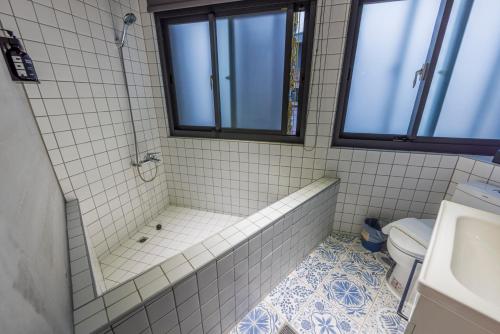 a bathroom with a tub and a toilet at Meng Yun Ge Hotel in Jiaoxi