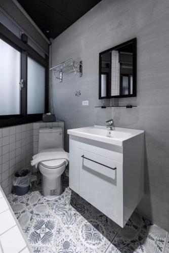 a bathroom with a sink and a toilet at Meng Yun Ge Hotel in Jiaoxi