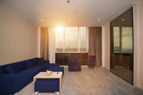 a living room with a blue couch and a table at Darin Plaza Hotel in Erbil