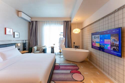 a bedroom with a bed and a tub and a tv at Dali Upland International Youth Hostel, near the south gate of the ancient city ,5 mins walk to the old town, Close to Er Hai Lake, convenient payment and visa cards are accepted in Dali
