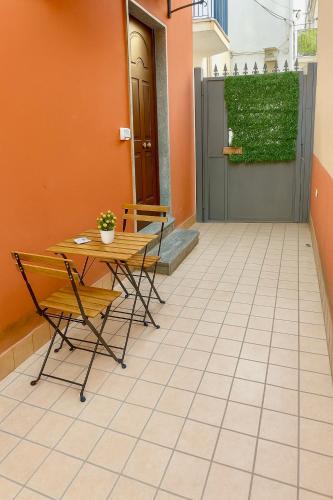 a patio with a table and chairs on a tiled floor at Annette Home Scafati-Pompei in Scafati