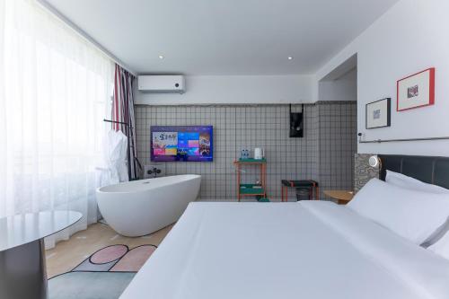a bedroom with a white tub and a bathroom at Dali Upland International Youth Hostel, near the south gate of the ancient city ,5 mins walk to the old town, Close to Er Hai Lake, convenient payment and visa cards are accepted in Dali
