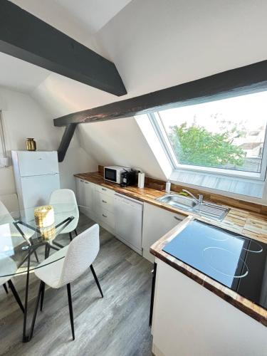 una cucina con tavolo in vetro e finestra di Soh Rent Appartement 3p Schiltigheim a Schiltigheim