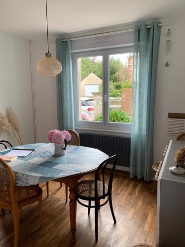 une salle à manger avec une table et des chaises et une fenêtre dans l'établissement 5 min de la mer à pied, jolie maison des années 30, à Saint-Quay-Portrieux