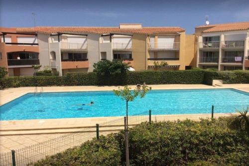 une grande piscine devant un immeuble dans l'établissement CAPAO Joli 2 pièces cabine piscine Richelieu Cap d'Agde, au Cap d'Agde
