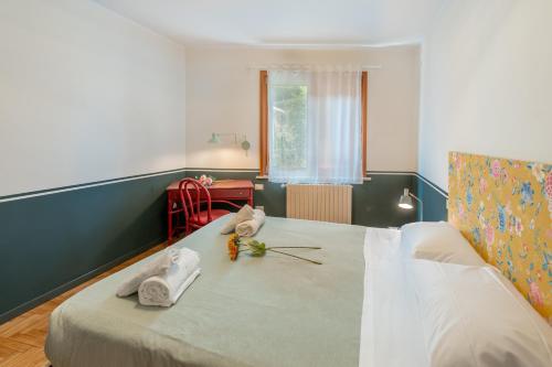 a bedroom with a bed with towels and flowers on it at Il Nido sul Po in Casalmaggiore