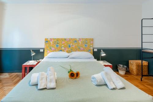 a bedroom with a bed with towels and a flower on it at Il Nido sul Po in Casalmaggiore