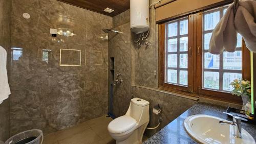 a bathroom with a toilet and a sink at StayVista at Raas Villa with BBQ & Bonfire in Chail