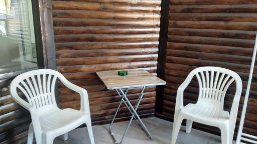two white chairs and a table on a porch at Victoria Family Hotel in Balchik