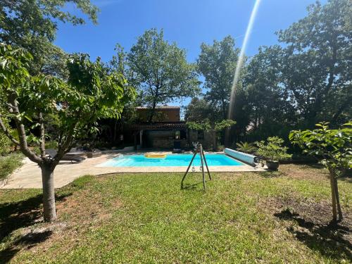 una piscina en un patio con un arco iris en Dépendance individuelle, en Nans-les-Pins