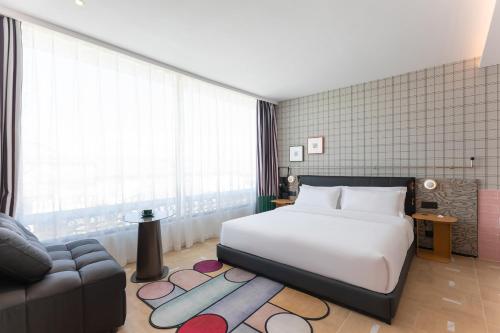 a bedroom with a large white bed and a couch at Dali Upland International Youth Hostel, near the south gate of the ancient city ,5 mins walk to the old town, Close to Er Hai Lake, convenient payment and visa cards are accepted in Dali