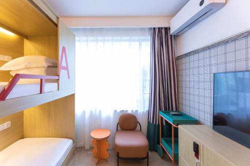 a small room with a bed and a tv at Dali Upland International Youth Hostel, near the south gate of the ancient city ,5 mins walk to the old town, Close to Er Hai Lake, convenient payment and visa cards are accepted in Dali