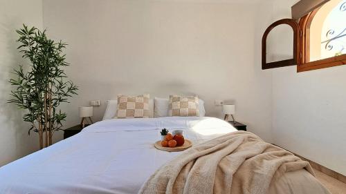 a bedroom with a bed with a plate of fruit on it at La Karina in Denia