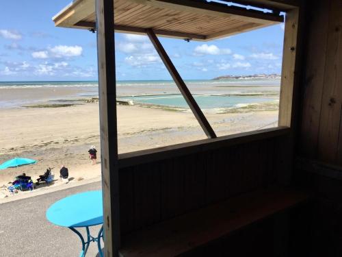 a view of the beach from the window of a beach house at Très proche Granville Résidence Midship in Saint-Pair-sur-Mer