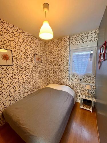 une petite chambre avec un lit et une fenêtre dans l'établissement 17 Rue du Puits de la Place, à Granville