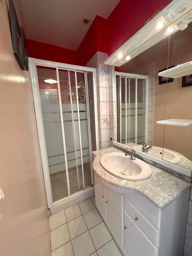 une salle de bain blanche avec un lavabo et une douche dans l'établissement 17 Rue du Puits de la Place, à Granville