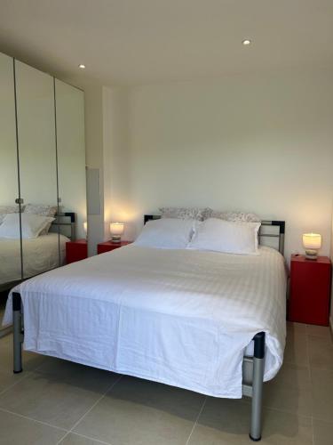 une chambre avec un grand lit blanc avec deux lampes dans l'établissement Villa Campo di Pace, à Sisco