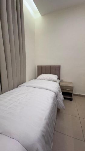 a bedroom with a large bed with white sheets at يزن للاجنحة الفندقية in Aqaba