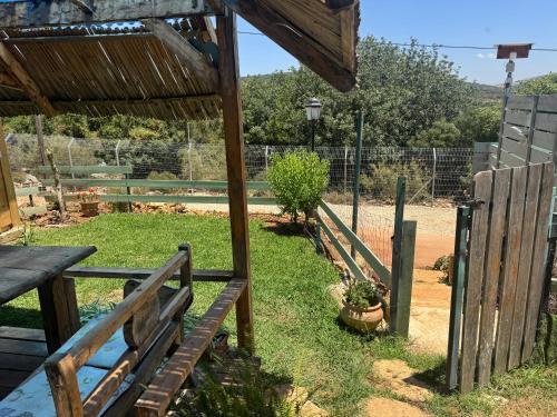 a garden with a wooden bench and a fence at שיר החורש in Shomera