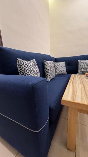 a blue couch with pillows on it next to a table at يزن للاجنحة الفندقية in Aqaba